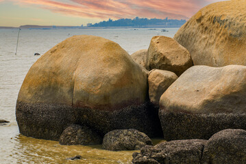 Crushed stones and huge rocks on the beach