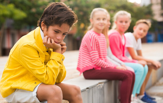 Portrait of boy 9-12 years old who is taking offense on his friends in the park.