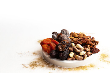 Various nuts and dried fruits, on a white-gold background. Vegan and vegetarian concept, healthy source of fat. Healthy snack assortment