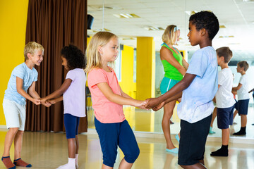 Positive little boys and girls dancing pair dance in the ballet studio. High quality photo