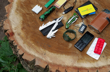 A set of items for survival in the city on a tree stump.