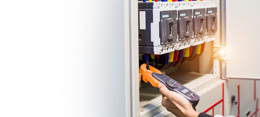 Electrical engineer tests the operation of the electric control cabinet on a regular basis for...