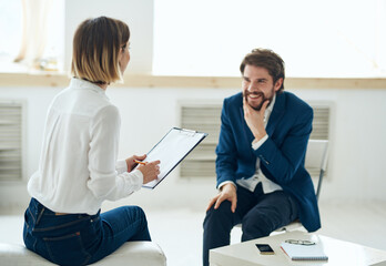 Obraz premium a man explains something to a woman to a psychologist indoors near a window
