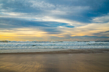 Fototapeta na wymiar Empty sand beach at sunset. Beautiful seascape in gold and blue colors