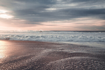 Pink sunset on the beach, beautiful seascape with cloudy sky background in light blue and pink colors