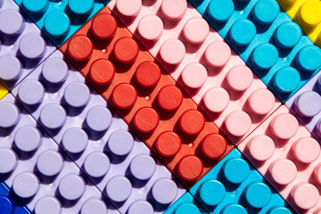 children's play background: the plane of plastic multi-colored bricks, blur, selective focus