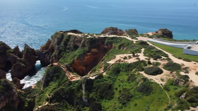 Orbit Aerial View Of Of Coastal Rock Formations With Caves and the Lighthouse, Ponta Da Piedade, Portugal