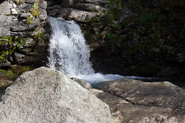 Naklejka na ściany i meble Beautiful waterfall in the mountains among the rocks