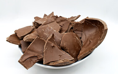 Broken chocolate easter egg in a bowl isolated on white background