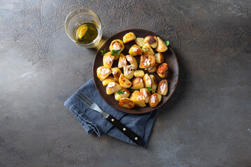  Top view of Patatas bravas in wooden plate and beer on cocnrete background. Traditional Spanish tapa