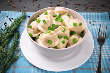 Meat dumplings - Russian dumplings, dumplings with meat on a plate on a black background