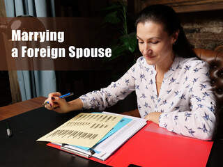 Fototapeta premium Business concept about Marrying a Foreign Spouse Female office workers with yellow shirt holding and writing documents on office desk