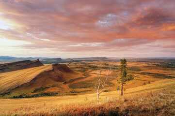Obraz premium Mountain range Chests sunset evening light and cloudy sky silence bizarre red stones and steppe in Khakassia