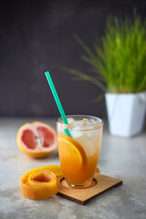 Pink and Orange Summer ice cocktail on cafe table. Cold and healthy drink with oranges and grapefruit. Antioxidant
