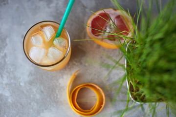 Pink and Orange Summer ice cocktail on cafe table. Cold and healthy drink with oranges and grapefruit. Antioxidant