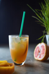 Pink and Orange Summer ice cocktail on cafe table. Cold and healthy drink with oranges and grapefruit. Antioxidant