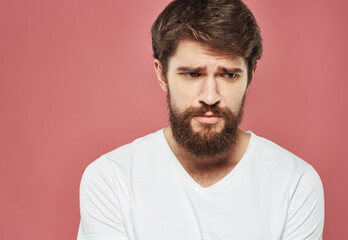 Fototapeta premium Man with sad face on pink background cropped view of white t-shirt