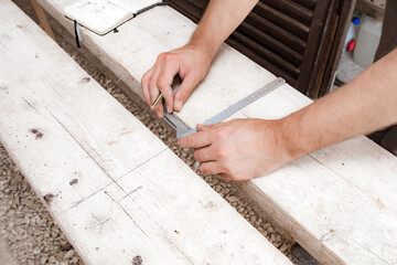 Male carpenter working with wood material in a garage.
