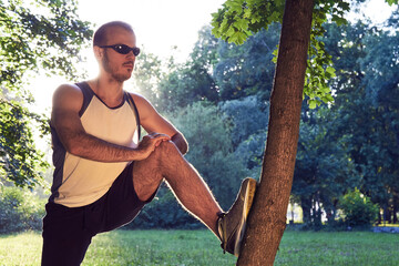 Sporty young adult man training in the park.