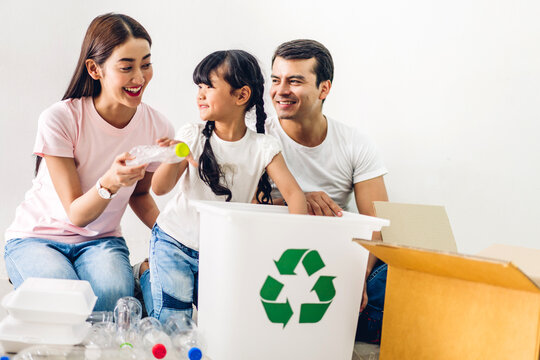 Happy Smiling Asian Family Father And Mother With Little Asian Girl Having Fun Putting Empty Recycle Plastic Bottle Garbage And Reduce Ecology Environment Into The Recycle Box