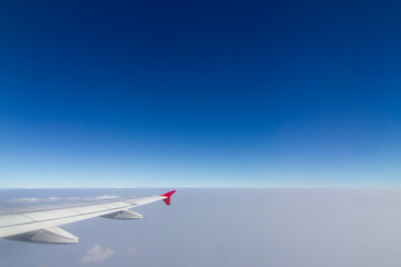 Fototapeta premium An airplane wing in the sky The sky atmosphere is cloudy and dust is thick. Fly on the Asian continent, Thailand.