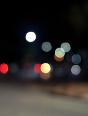 Out of focus defocused blurred bokeh of cars and traffic lights at night on city street.