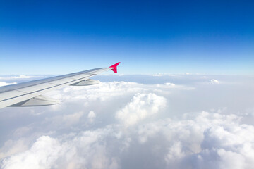 Fototapeta premium An airplane wing in the sky The sky atmosphere is cloudy and dust is thick. Fly on the Asian continent, Thailand.