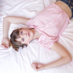 Adolescente aux yeux bleu se reposant sur son lit, photo prise de haut