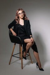 Business woman in glasses in a black dress