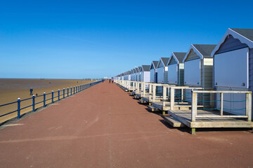 A row of beach huts lined along the promenade at the English seaside in Blackpool