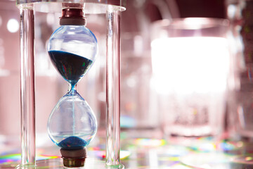 Fototapeta premium Blue hourglass on gray background close up