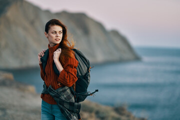 woman tourist with backpack near the sea on nature mountains in the background lifestyle