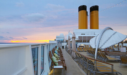 Luxury sun loungers and deck lounge chairs on outside terrace, patio or balcony sun pool deck of...