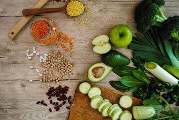 Obraz na płótnie Canvas Green vegetables and fruits on a wooden background.