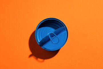Aesthetic concept with blue painted tin can on orange background
