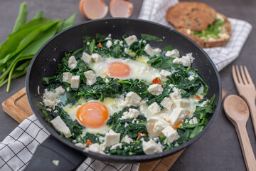 Green shakshuka. Fried eggs with wild garlic and feta cheese