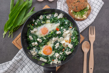 Green shakshuka. Fried eggs with wild garlic and feta cheese