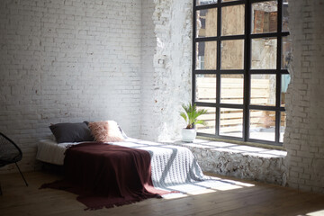Loft bedroom interior with big windows and light walls