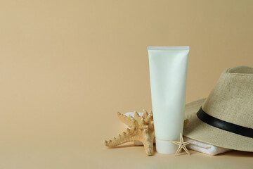 Sea accessories and sunscreen on beige background