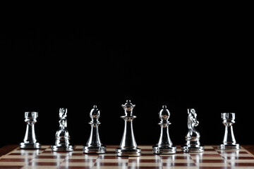 Silvery chess figures standing on chessboard