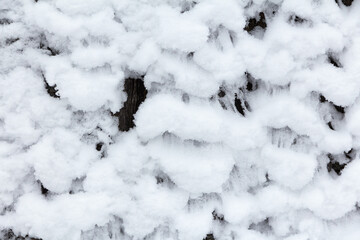 Snow covered wooden fence surface