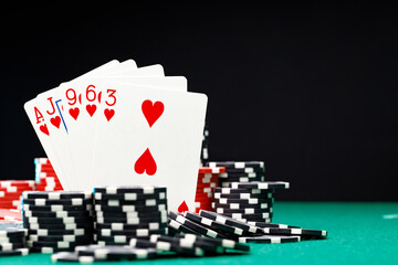 Poker chips and playing cards on black background