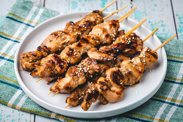 Grilled Asian Chicken Barbecue (BBQ)  seasoned with seasoned with sesame seeds (center)
