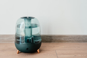 Modern air humidifier on a white wall background. Humidifier spreading steam into the living room