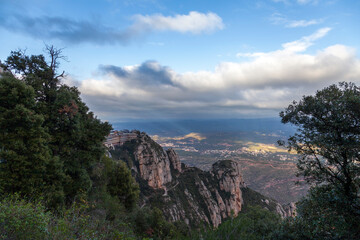 Breathtaking view of the Montserrat mountain range on a sunny spring day near Barcelona, Catalonia, Spain. Colorful mountain landscape. The shadow of the clouds falls to the ground.