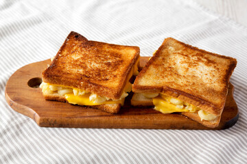 Homemade Grilled Macaroni and Cheese Sandwich on a rustic wooden board, low angle view.