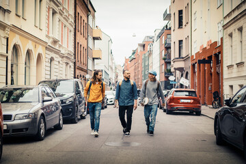 Male skaters walking on street in city