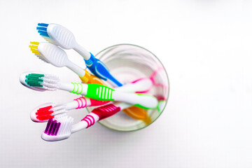 five toothbrushs in a glass cup on the bathroom table top view