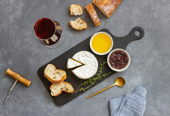 Fototapeta na wymiar Camembert cheese with toasts, honey and jam. Wine snack.