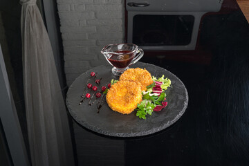 Suluguni cheese with sauce and fresh herbs on slate